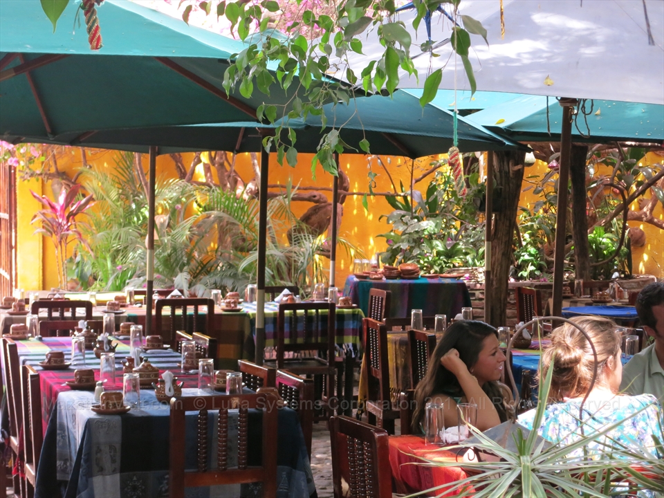 Handcrafted wood tables and colonial arches inside the restaurant patio