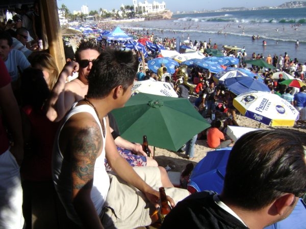 Massive night crowds and neon lights tracking the party atmosphere at Joe's Oyster Bar deck