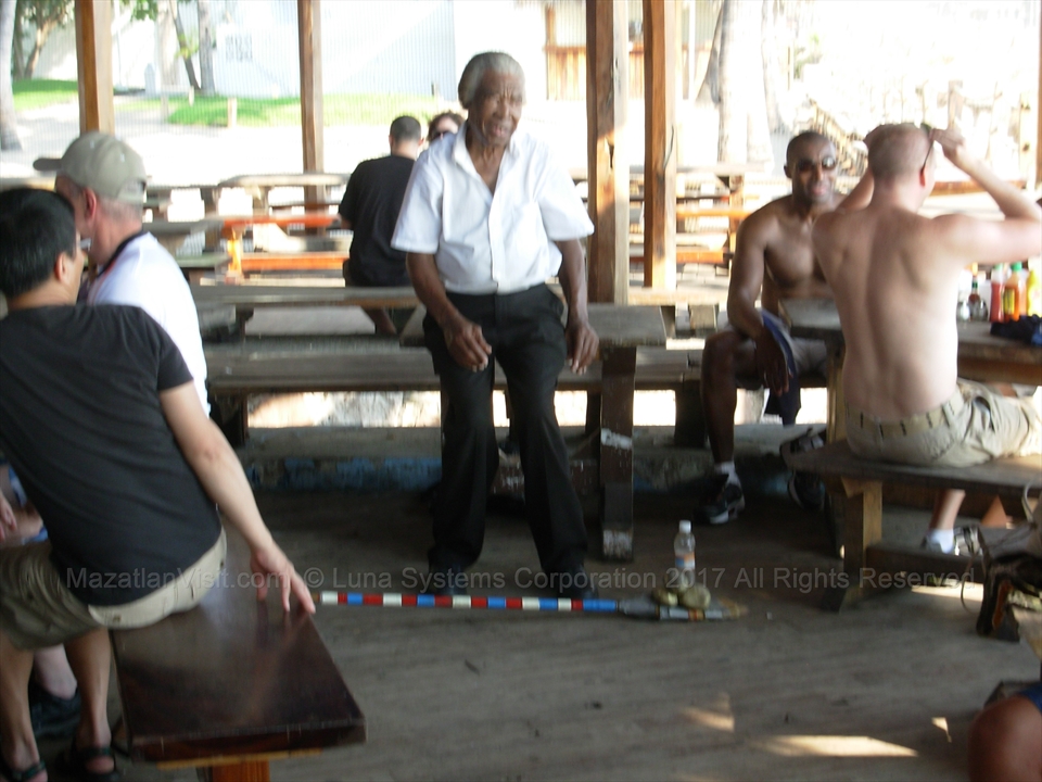 Calvin demonstrating his weighted broom challenge to tourists on the sand