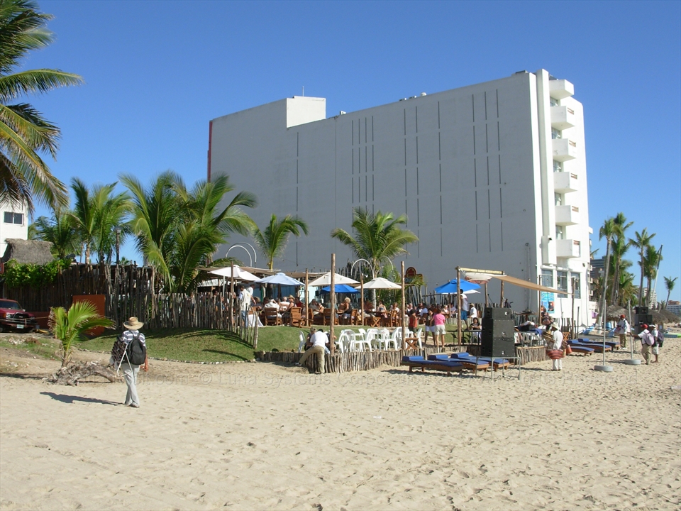 Beachfront tables set up on the sand with the offshore islands visible in the background