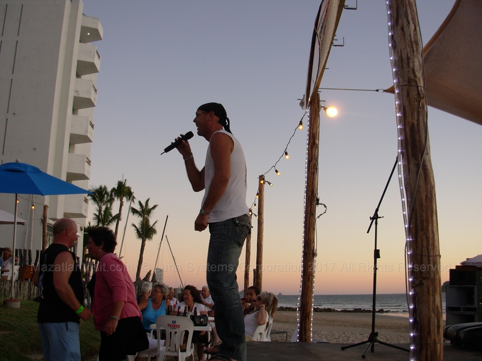 Guests dancing on the sand in front of the live music stage