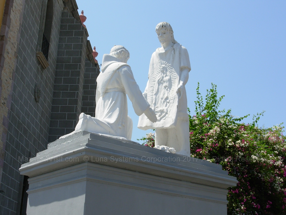 The historic bronze statue of Christ welcoming churchgoers at the perimeter gate rails