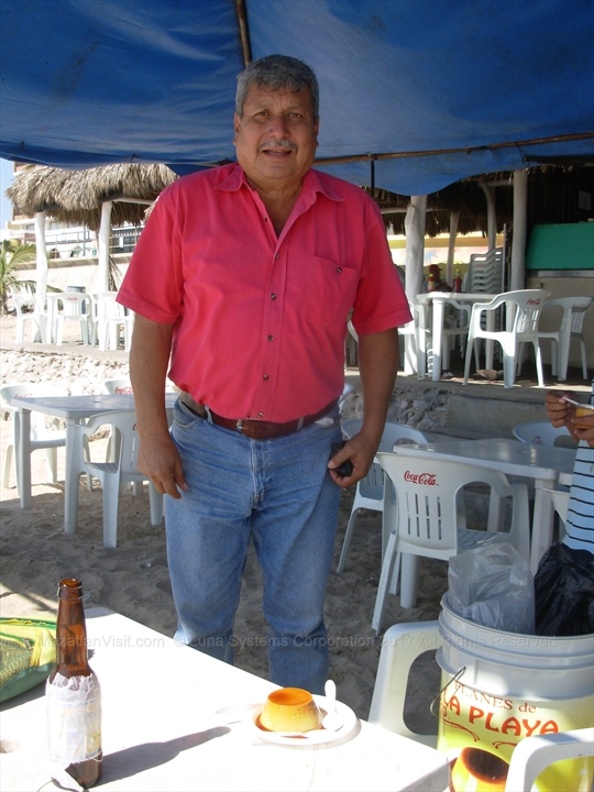Luis carrying his container of fresh homemade flan along the beach sands