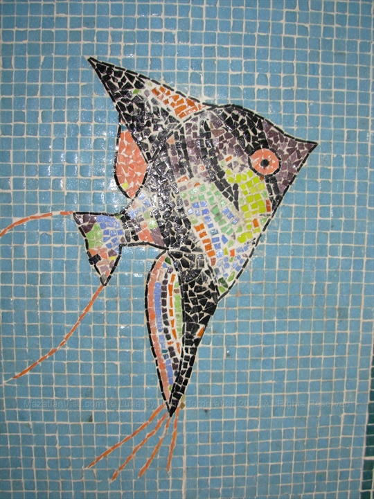 A detailed glass-tile mosaic depicting a starfish and sea plants on the tunnel walls