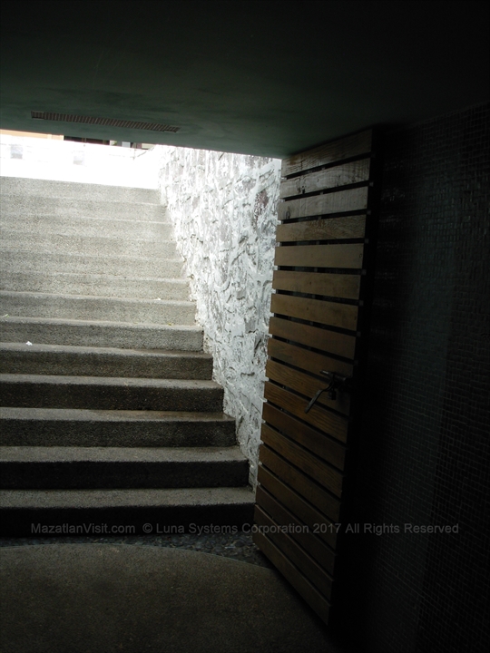 Looking down the stairs into the lit tiled pedestrian passageway