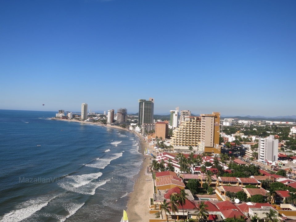Sleek modern beachfront hotel towers looking over blue ocean pools