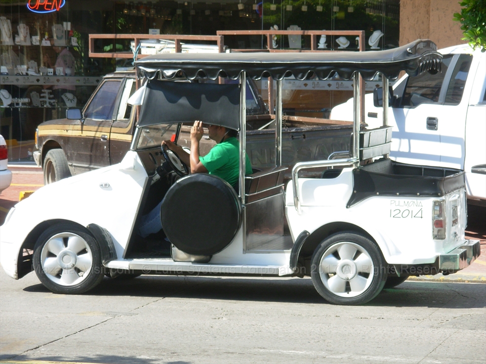 Traditional open air pulmonia taxi cruising down the street