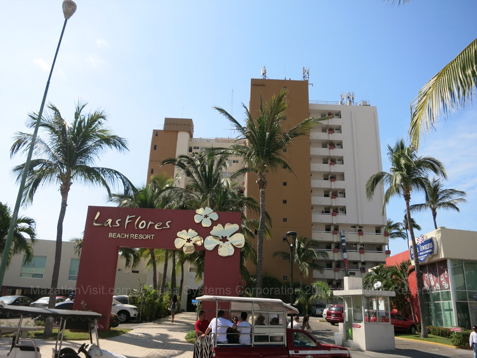 The beach facing multi story hotel tower of Las Flores Beach Resort