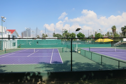Professional layout tennis courts lit up at a local country club resort