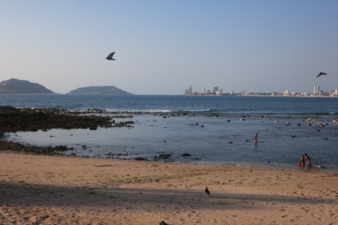 Families wading in the shallow protected cove of Los Pinitos beach