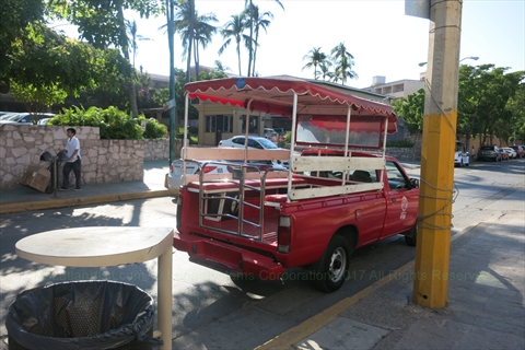 Bright red custom Auriga passenger truck taxi parked near the shoreline