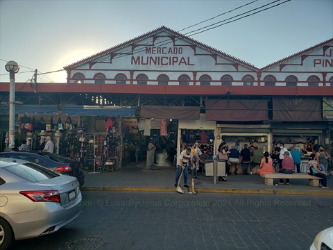 The iconic ironwork structure and bustling entryway of Mercado Pino Suarez