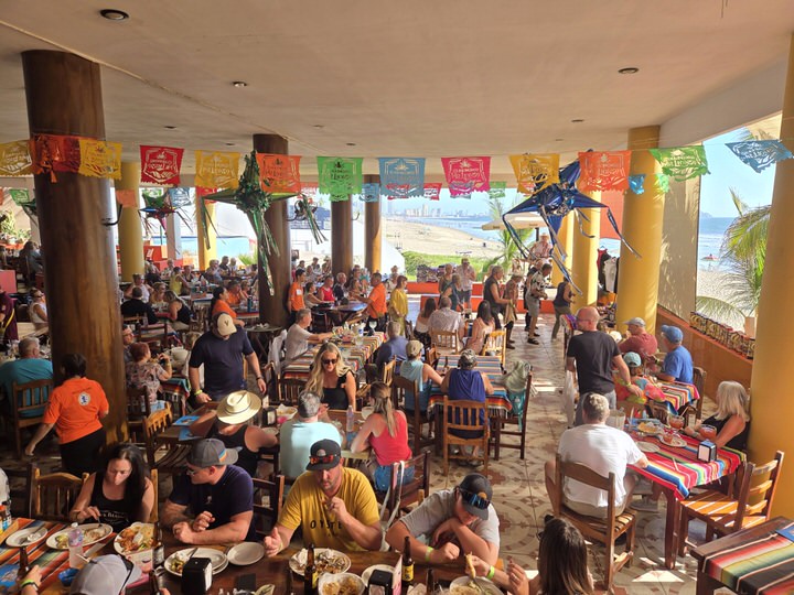 Live music performance crowd filling the open air palapa space at Mr Lionso restaurant