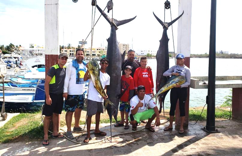 Local fishermen proudly displaying a large catch of fresh red snapper at the docks