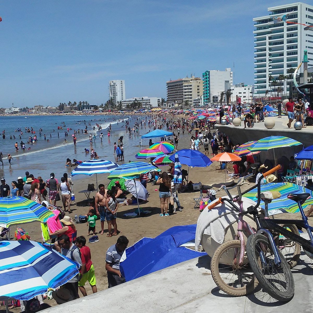 Families enjoying the warm ocean waves and activities along the main bay during spring break