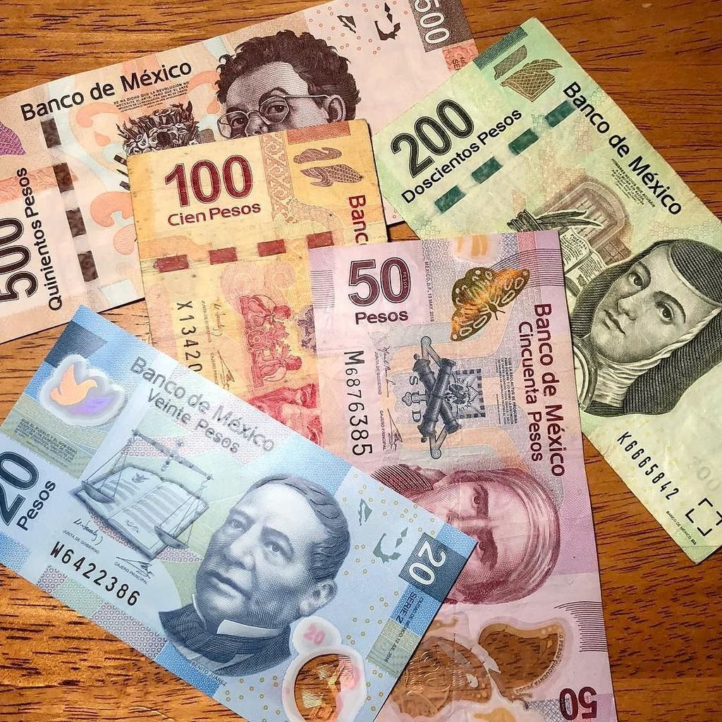 Mexican peso banknotes on a table mapping out travel budgets