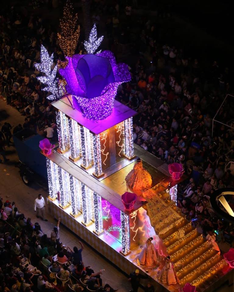 Colorfully dressed carnival dancers performing routines along the concrete boardwalk layout