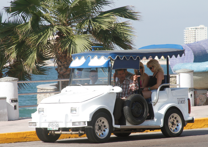 Open air taxi traveling parallel to the sandy beaches of Mazatlán