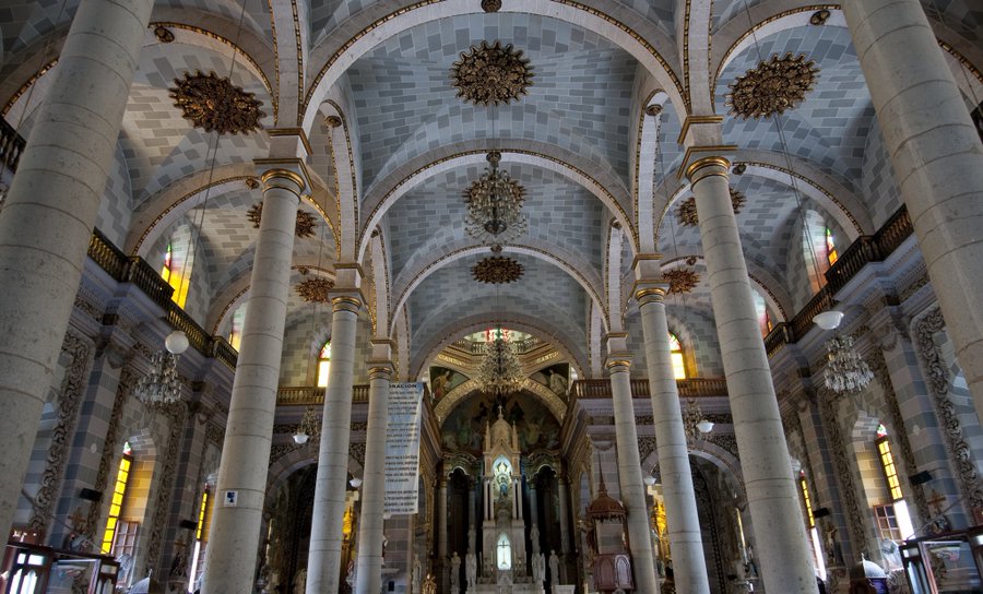 Interior view of the main altar showing the expansive gold leaf columns and canopies