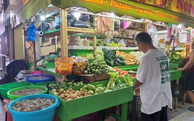 Fresh produce stands inside the municipal market corridor