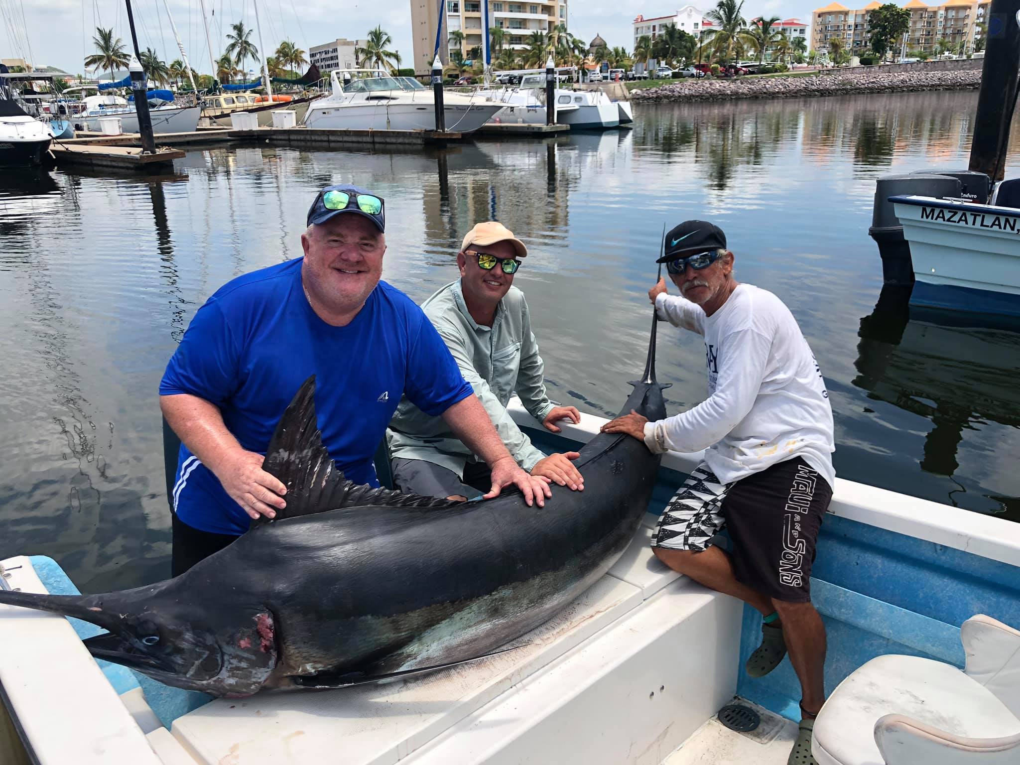 Anglers setting up heavy outriggers for offshore trolling