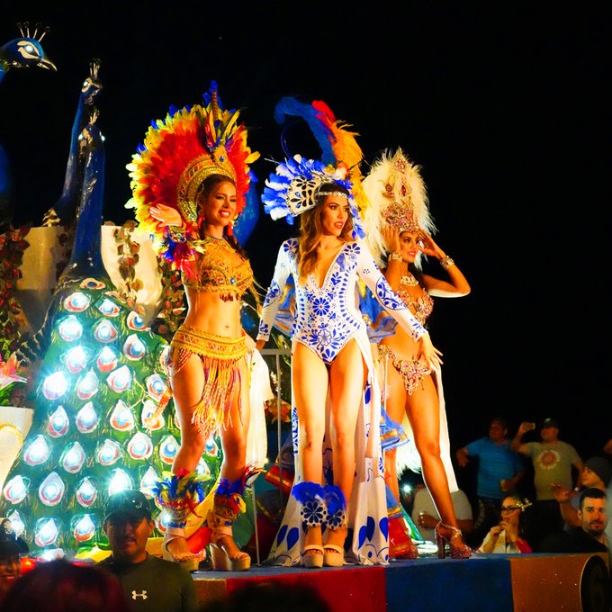 Towering illuminated float structure depicting marine themes moving past palm lines