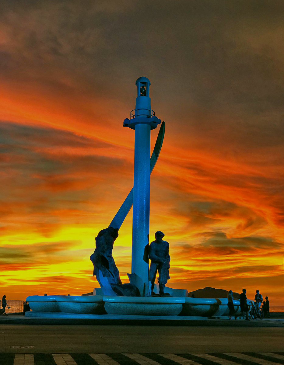The sun setting directly behind the historic Fisherman's Monument layout along the Malecón