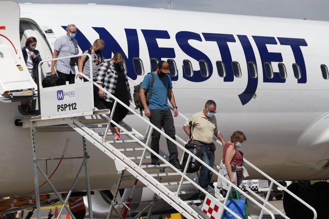 Passengers deplaning an aircraft via mobile stairs onto the open tarmac at MZT airport