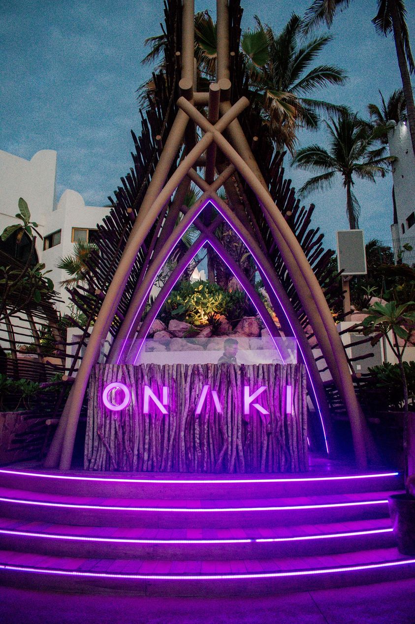 Modern white cabanas and daybeds bordering the sparkling swimming pool at Onaki