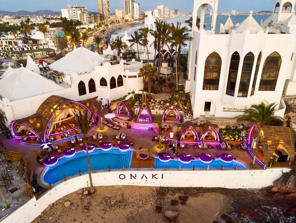 Chic white daybeds facing the Pacific ocean under shade umbrellas