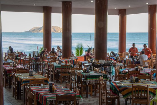 Oceanfront layout and palapa roofing of Mr. Lionso restaurant on Playa Bruja beach