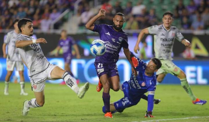 Match action showing local defenders tracking down the ball during a home game