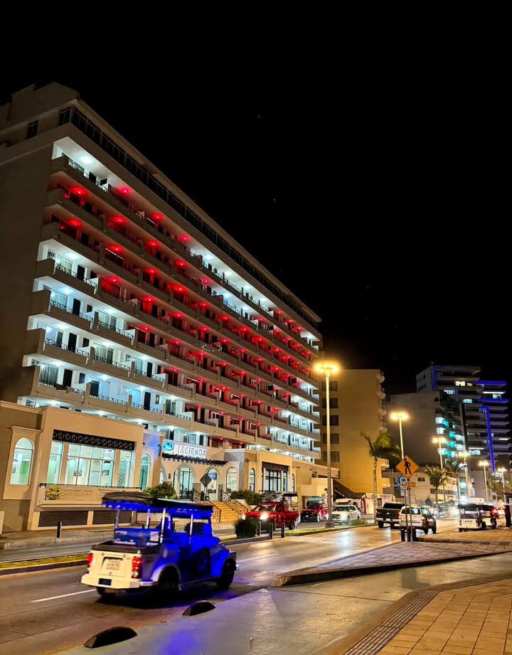The hotel facade lit up at night displaying a large geometric light pattern